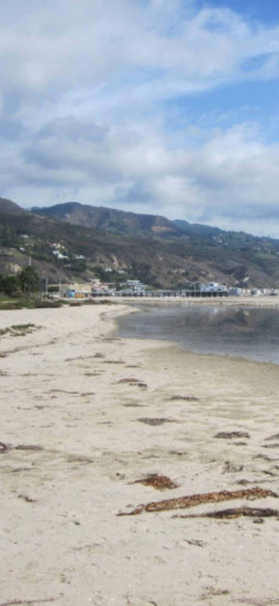 Mag-enjoy ng mga piktyureskong tanawin ng Malibu mula sa iyong iPhone XS Wallpaper