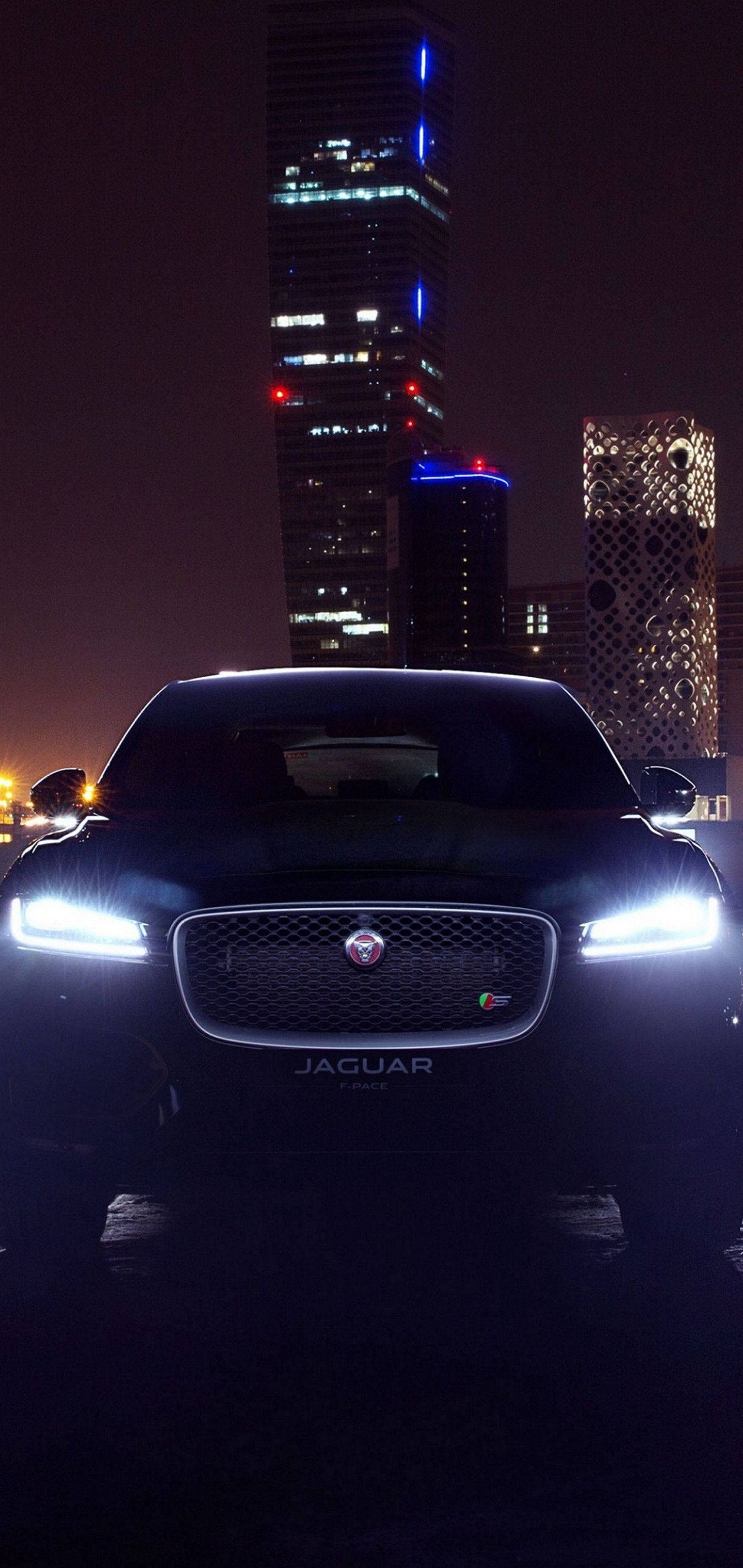 Maramdaman ang lakas at elegansa ng isang Jaguar na kotse sa gabi Wallpaper