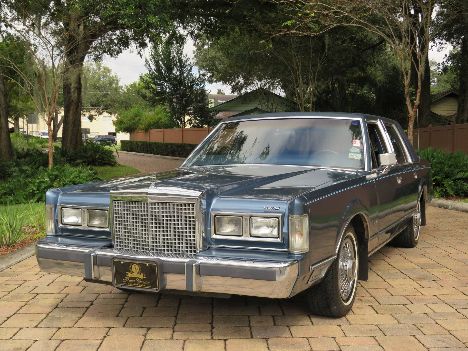 Marangal na 1986 Lincoln Town Car na naka-park sa isang sementadong driveway Wallpaper