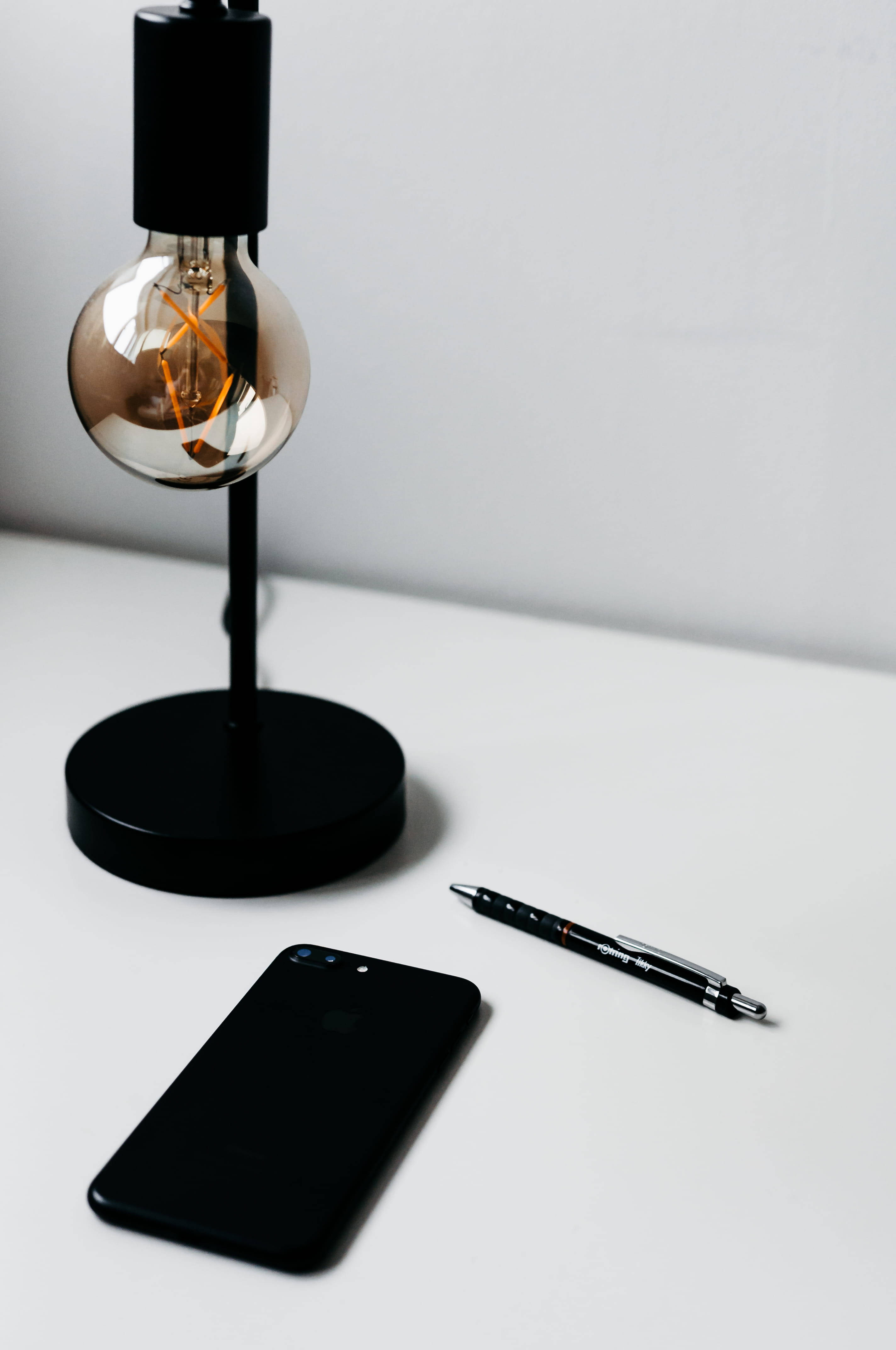 Naiilawang iPhone sa Minimalist na Mesa Wallpaper