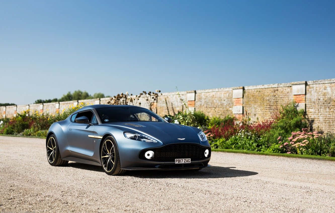 Nakakamamang Aston Martin Vanquish sa galaw sa isang magandang daan Wallpaper
