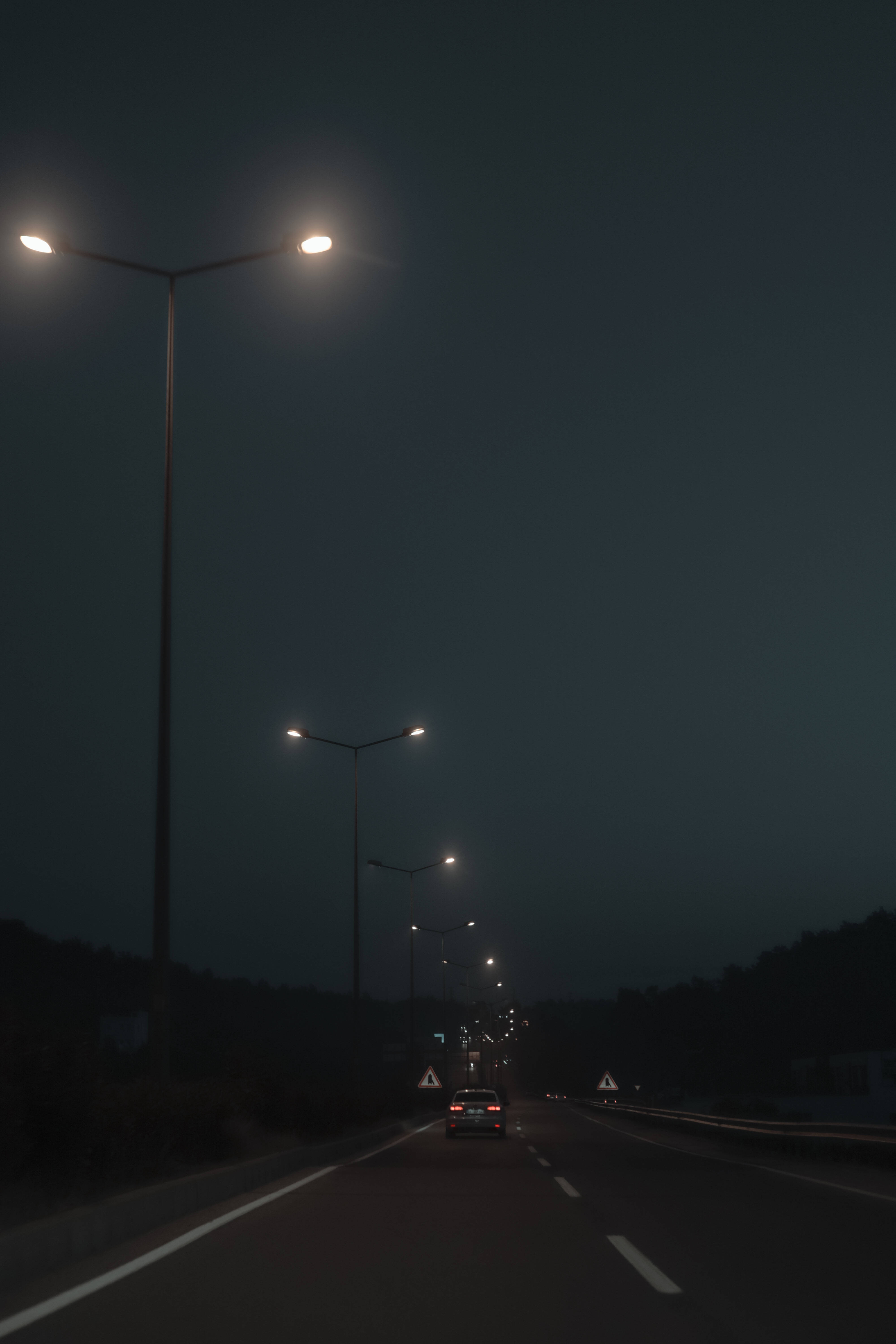 Matatandang mga Ilaw sa Daan sa Tabi ng Daan sa Isang Madilim na Gabi Wallpaper