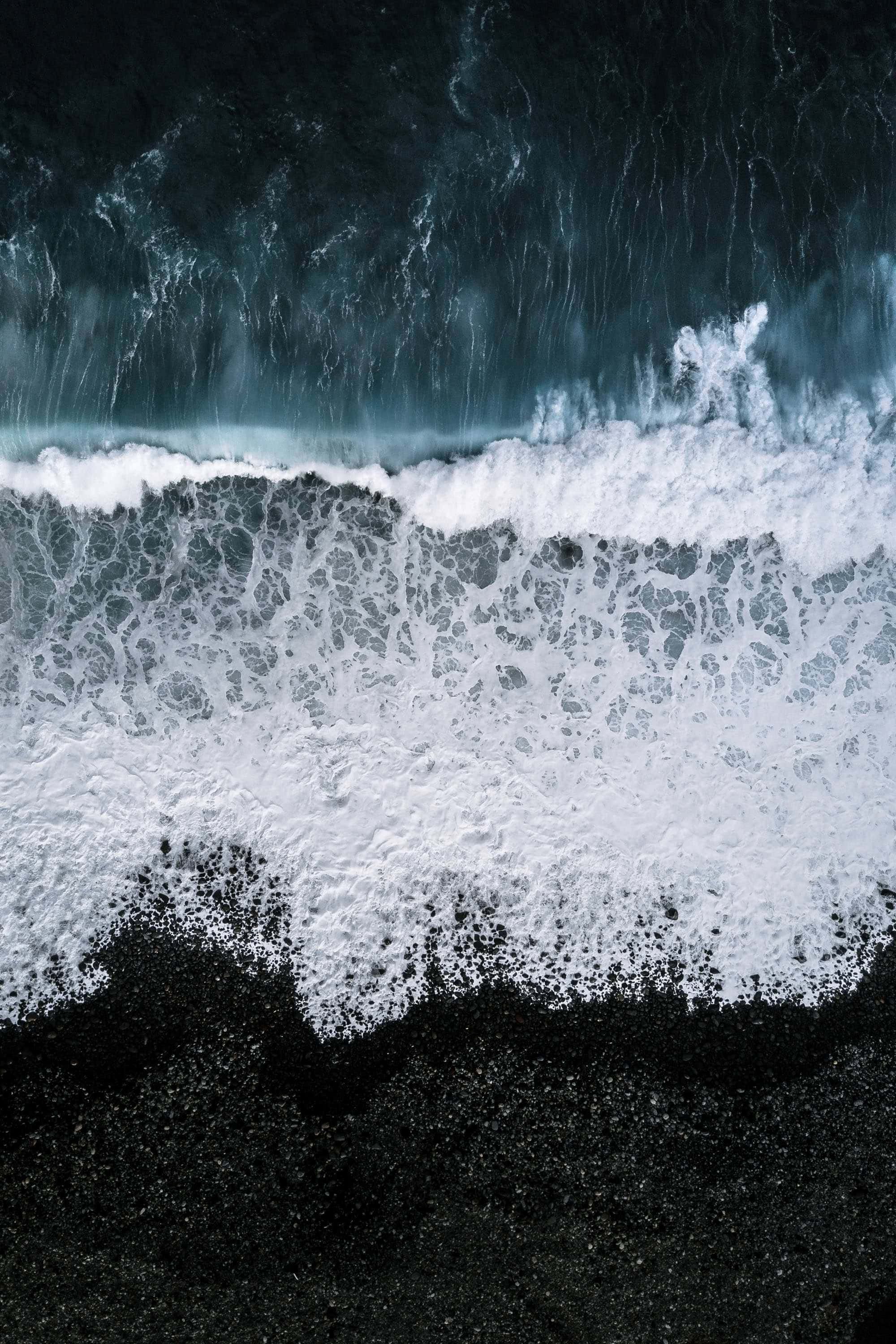 Ramdamhin ang init ng araw sa magagandang black sand beach. Wallpaper