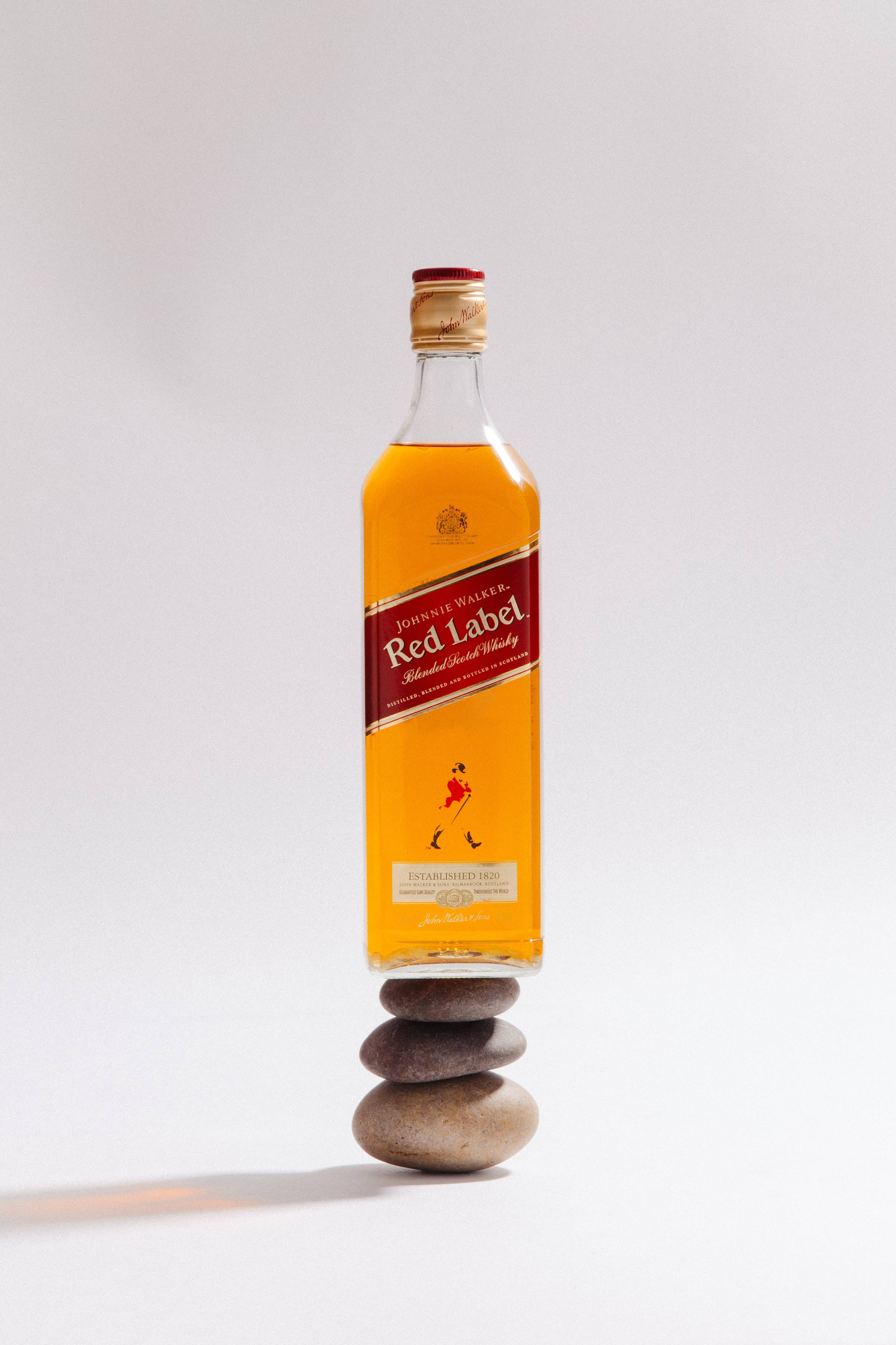 Bote ng Red Label Whiskey sa Isang Tambak ng Bato Wallpaper
