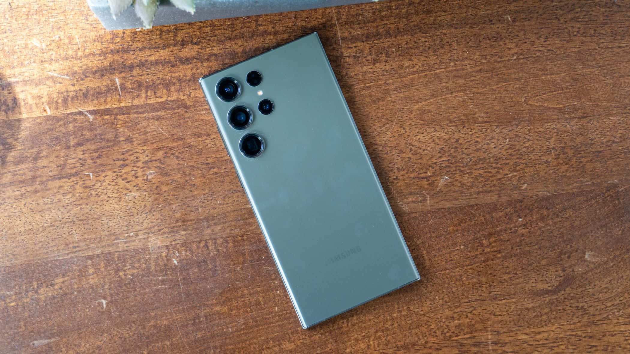 Samsung S23 Ultra Berdengang Likod na Kamera Array sa Kahoy na Ibabaw Wallpaper