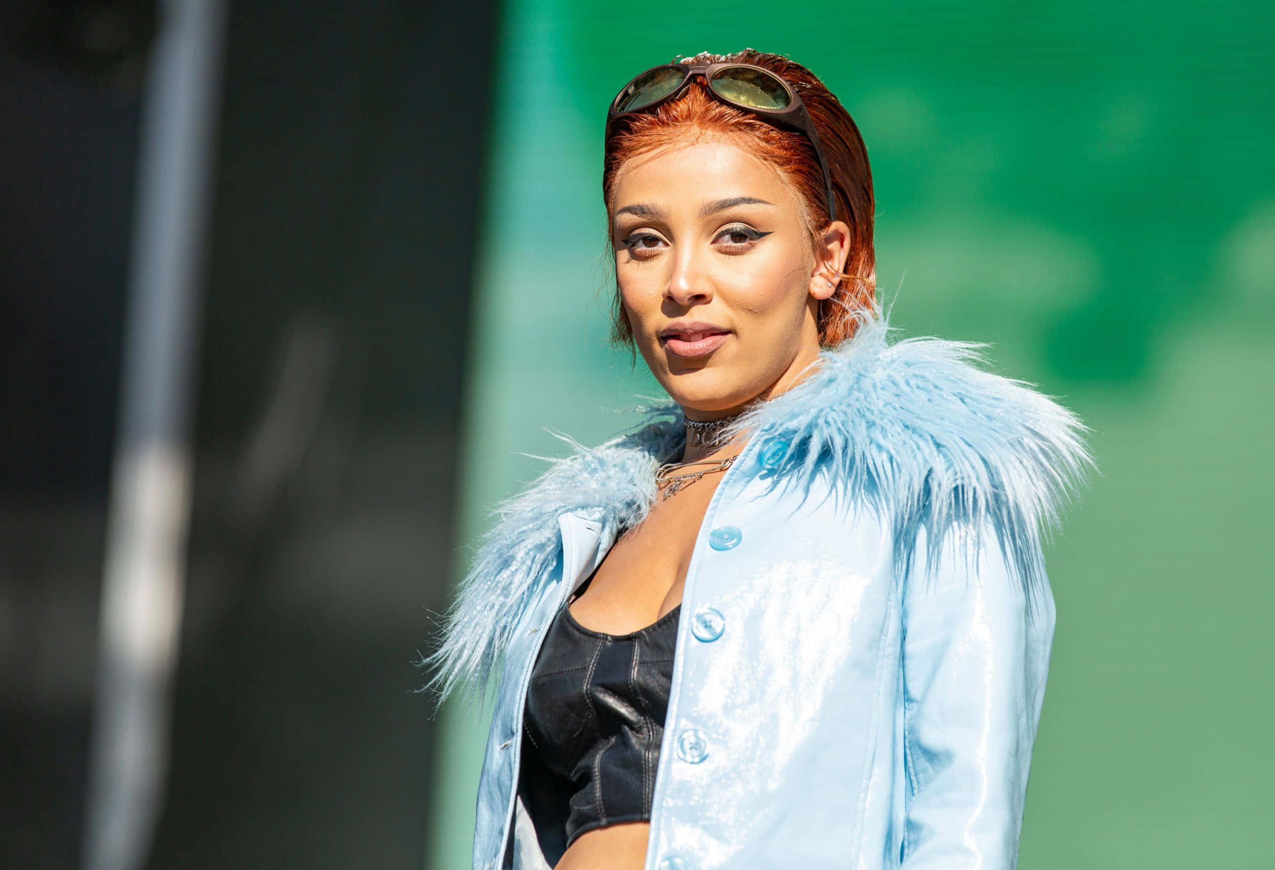 Si Doja Cat na nagpapose sa isang kasuotang gawa sa leather at latex Wallpaper