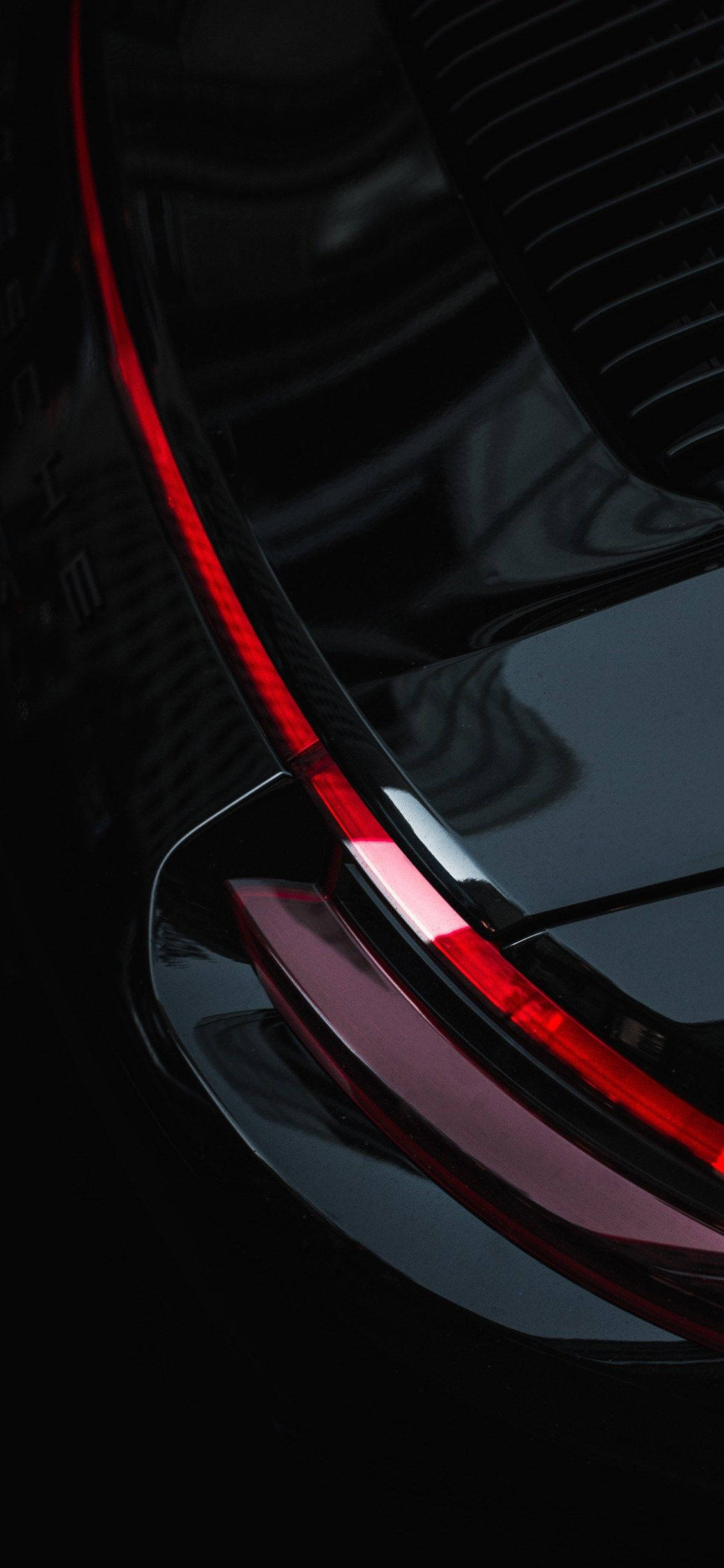 Sumasalamin ang Luho ng iPhone XR gamit ang Isang Itim na Kotse sa Isang Apoy na Daan. Wallpaper