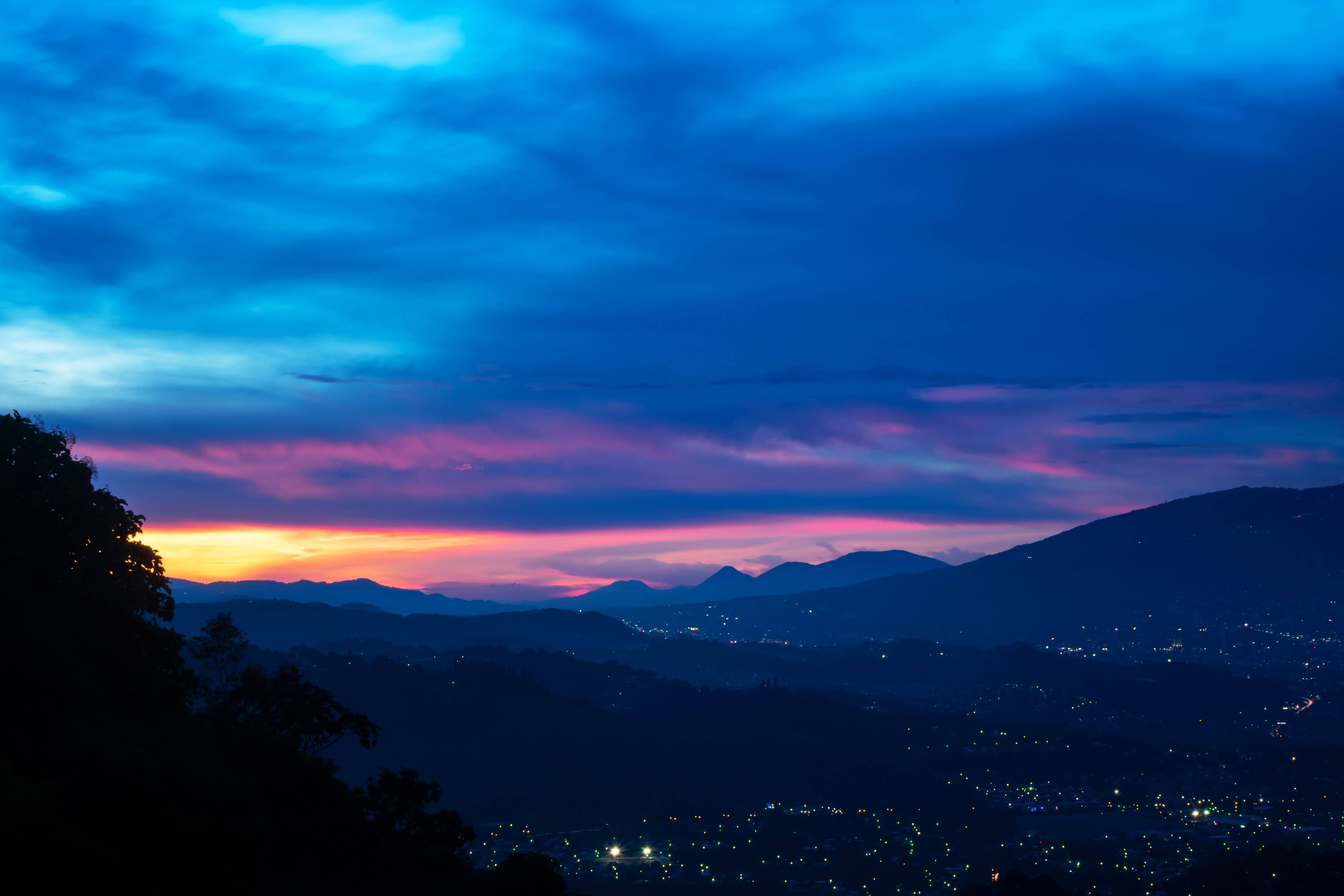 Tinatamasa ang tanawin ng maringal na hanay ng bundok sa isang araw na may asul na kalangitan. Wallpaper