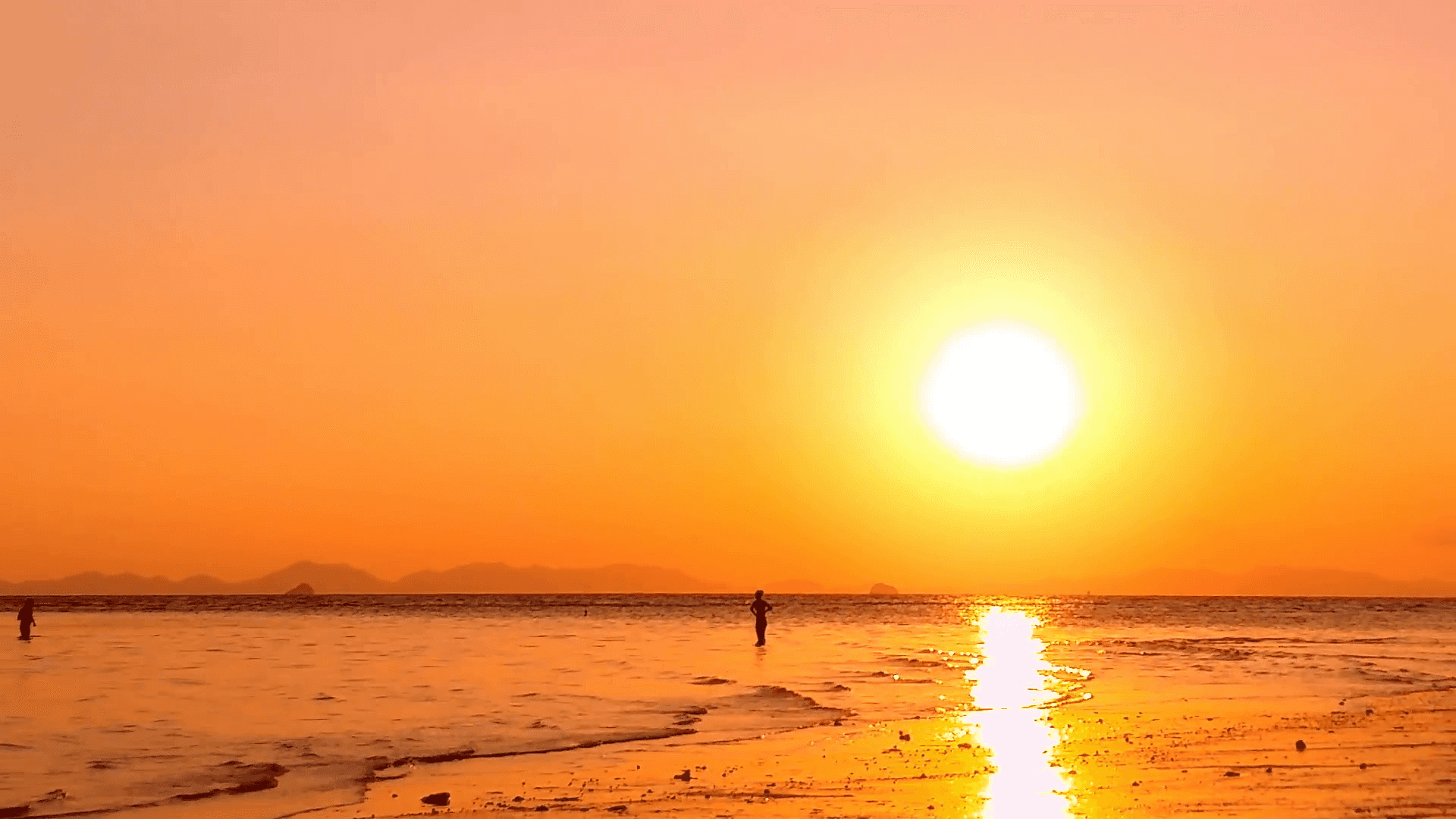 Yakapin ang ganda ng isang tahimik na paglubog ng araw sa dalampasigan Wallpaper