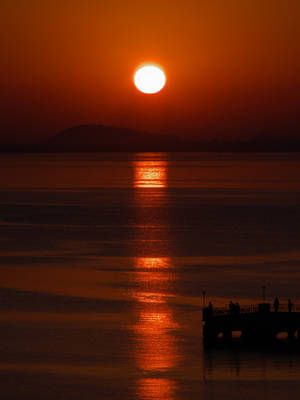 Pagsikat ng araw sa dagat na may silweta ng mangingisda na wallpaper