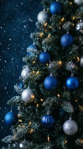 Isang madilim na asul na punong Pasko na may mga ilaw at niyebe sa isang madilim na taglamig na eksena.