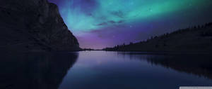 Ultrawide Aurora Borealis na makulay na pastel na asul at lila na langit na may mga bituin tanaw mula sa mga bundok