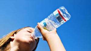 Babae na Umiinom ng Tubig mula sa Bote