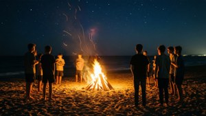 Mga teenager na nagtitipon sa paligid ng bonfire sa dalampasigan sa Ocean Waves.