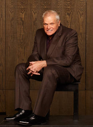 Brian Dennehy Suit Aesthetic Brown na May Kahoy na Background — Brown aesthetic GIF Wallpaper