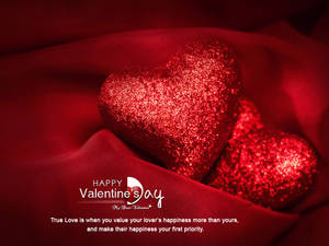 Dalawang makislap na puso sa tabi ng isa't isa sa malambot na pulang tela na may teksto na nagsasabing "Happy Valentine's Day" sa ilalim nila. — 4:3 Wallpaper