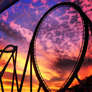 Roller coaster sa ibabaw ng purple orange clouds wallpaper — Motorola Razr 2026 Wallpaper