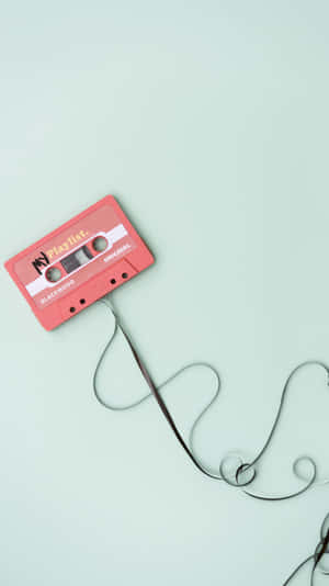 Isang cassette tape na nakakonekta sa isang kawad — Aesthetic music Wallpaper