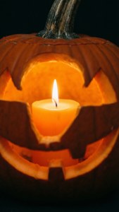 Close-up ng isang kandila sa loob ng kalabasa para sa intimate na aesthetic ng Halloween.