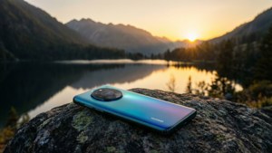 Isang Huawei phone sa isang bato na nakatanaw sa isang laweng bundok sa paglubog-lubog, payapa na tanawin. — Huawei Wallpaper