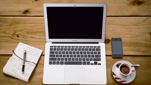 Macbook Air sa kahoy na mesa na may kagamitan sa pag-aaral — MacBook Air M2 Wallpaper