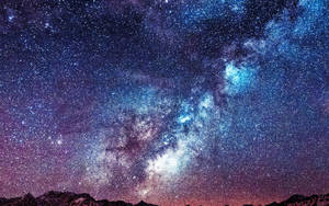 Macbook Air na may langit na puno ng bituin at bundok — MacBook Air M2 Wallpaper