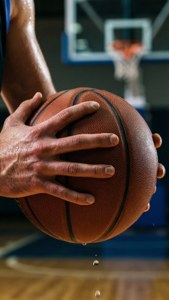 Close-up shot ng mga kamay na may hawak ng basketball na may matinding pokus at pawis. — Basketball GIF Wallpaper