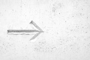 Right arrow sign on white concrete wall wallpaper