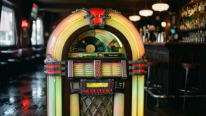 Isang jukebox na may neon lights sa isang madilim at retro na bar.