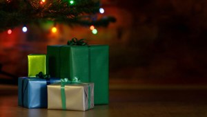 Makukulay na regalong nakasalansan sa ilalim ng Christmas tree na may kumikislap na mga ilaw. — Regalo Pasko Wallpaper