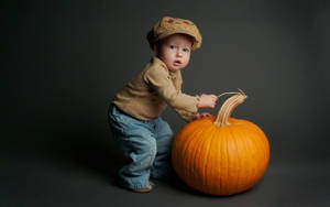 Wallpaper ng nakabibinging toddler sa kalabasa para sa Halloween.