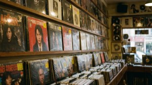 Mga pabalat ng album na naka-display sa isang record store, mainit na ilaw.