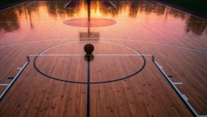 Napakagandang panoramikong tanawin ng isang basketball court na naliliwanagan ng mga kulay ng paglubog ng araw. — Basketball GIF Wallpaper