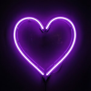 Isang kumikinang na simbolo ng pusong neon na kulay lila.