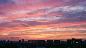 Isang makulay na kalangitan sa madaling araw sa itaas ng silweta ng skyline ng lungsod. — Tanawin ng langit Wallpaper
