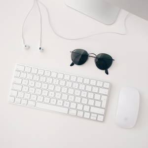 Minimalist wallpaper ng puting Apple MAC set-up na binubuo ng iMAC, wireless keyboard, magic mouse at earphone.