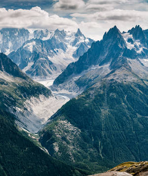 Aerial na larawan ng mga bundok sa ilalim ng maulap na langit na wallpaper. — Motorola Razr 70 Ultra Wallpaper