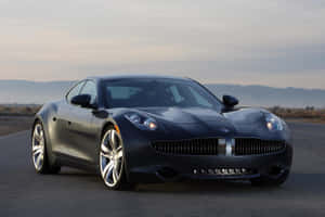 Ang Fisker Karma, isang luxury electric vehicle sa isang magandang coastal drive. — Surface Pro Wallpaper