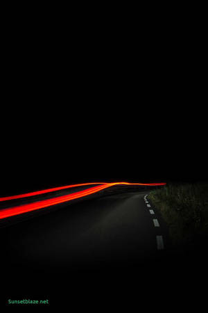 AMOLED wallpaper ng isang orange light na sumusunod sa daan.