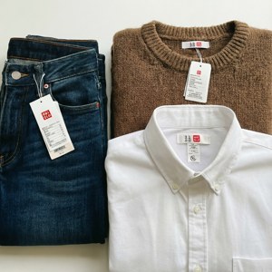 Flat lay ng mga damit ng Uniqlo na may mga tag. — Galaxy Watch Wallpaper