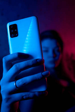 Woman With Phone In Neon Blue iPhone — Neon Wallpaper